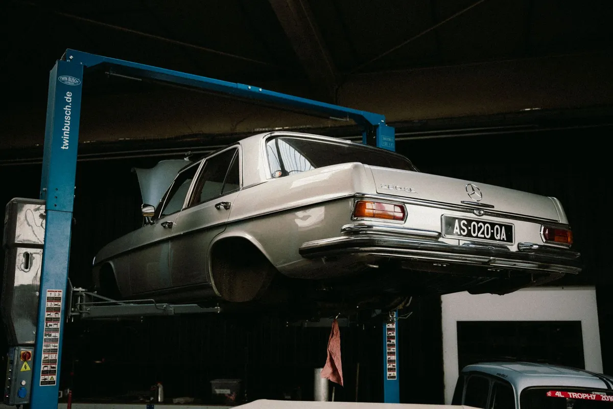 Klassischer Mercedes auf einer Hebebühne in einer Werkstatt